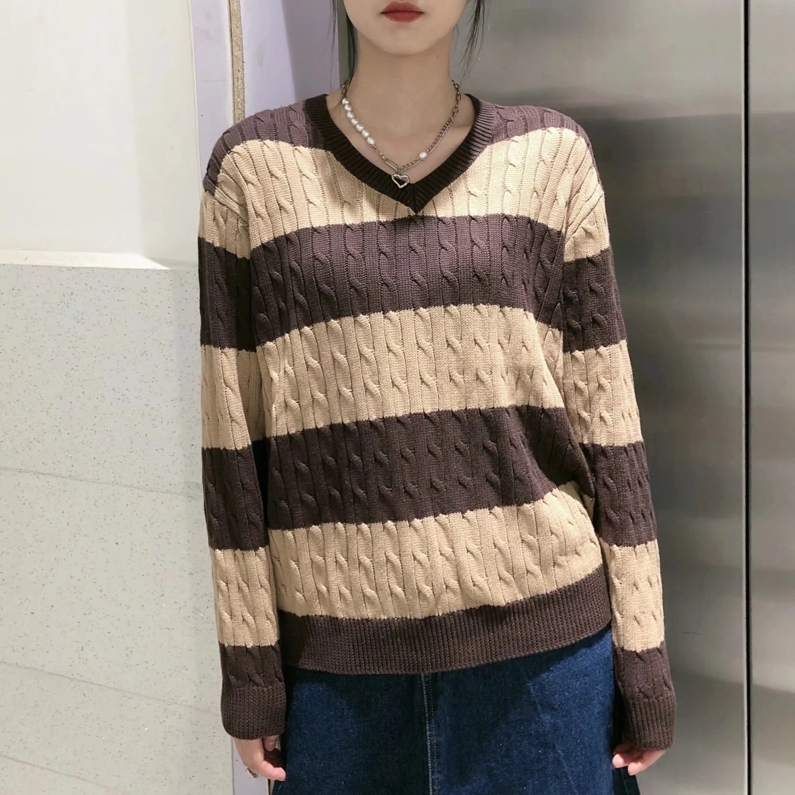 Suéter listrado com decote em V, tricô solto e detalhe torcido. Perfeito para um visual casual e confortável com um toque moderno. — foto 4