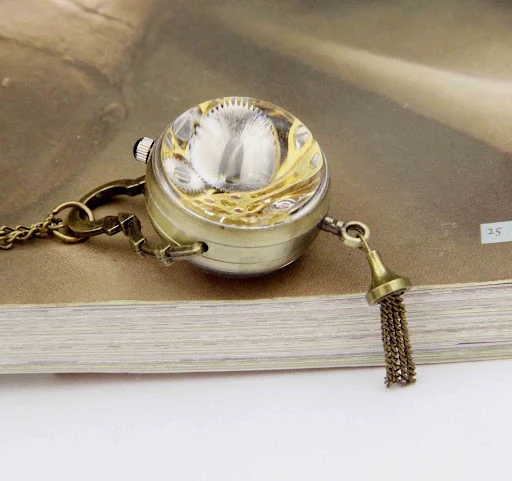 Title 4, Relógio de bolso mecânico com bola de cristal. ...