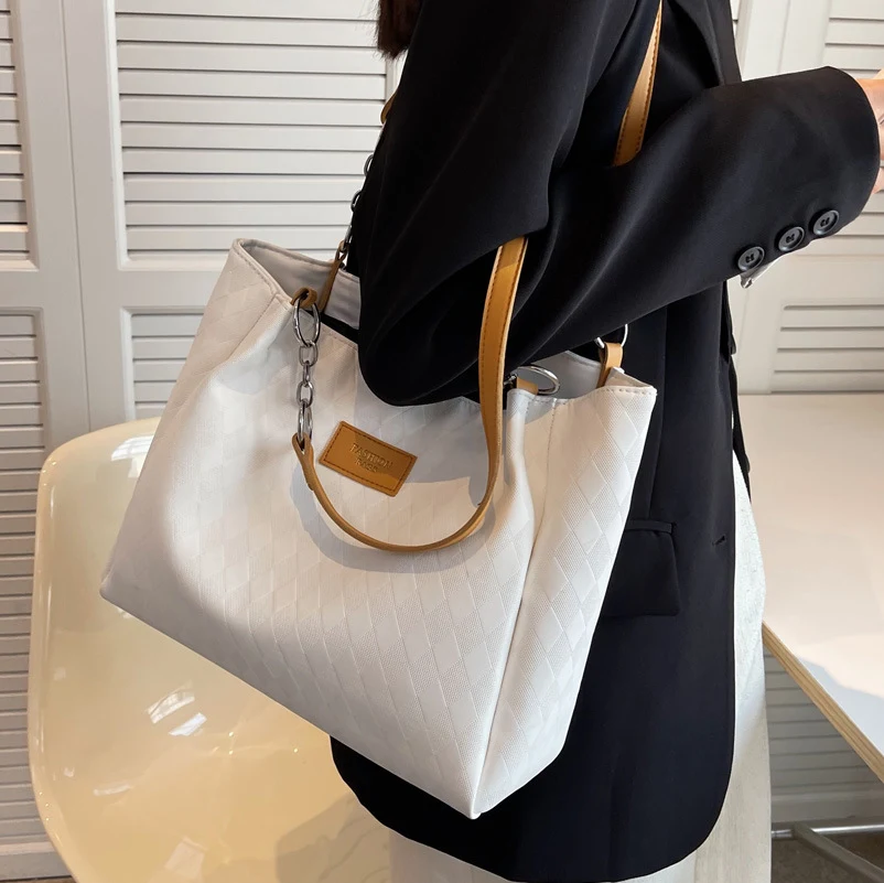 Bolsa de ombro feminina com corrente e padrão de losangos, ideal para compras. Elegância e praticidade para suas compras diárias. — foto 1