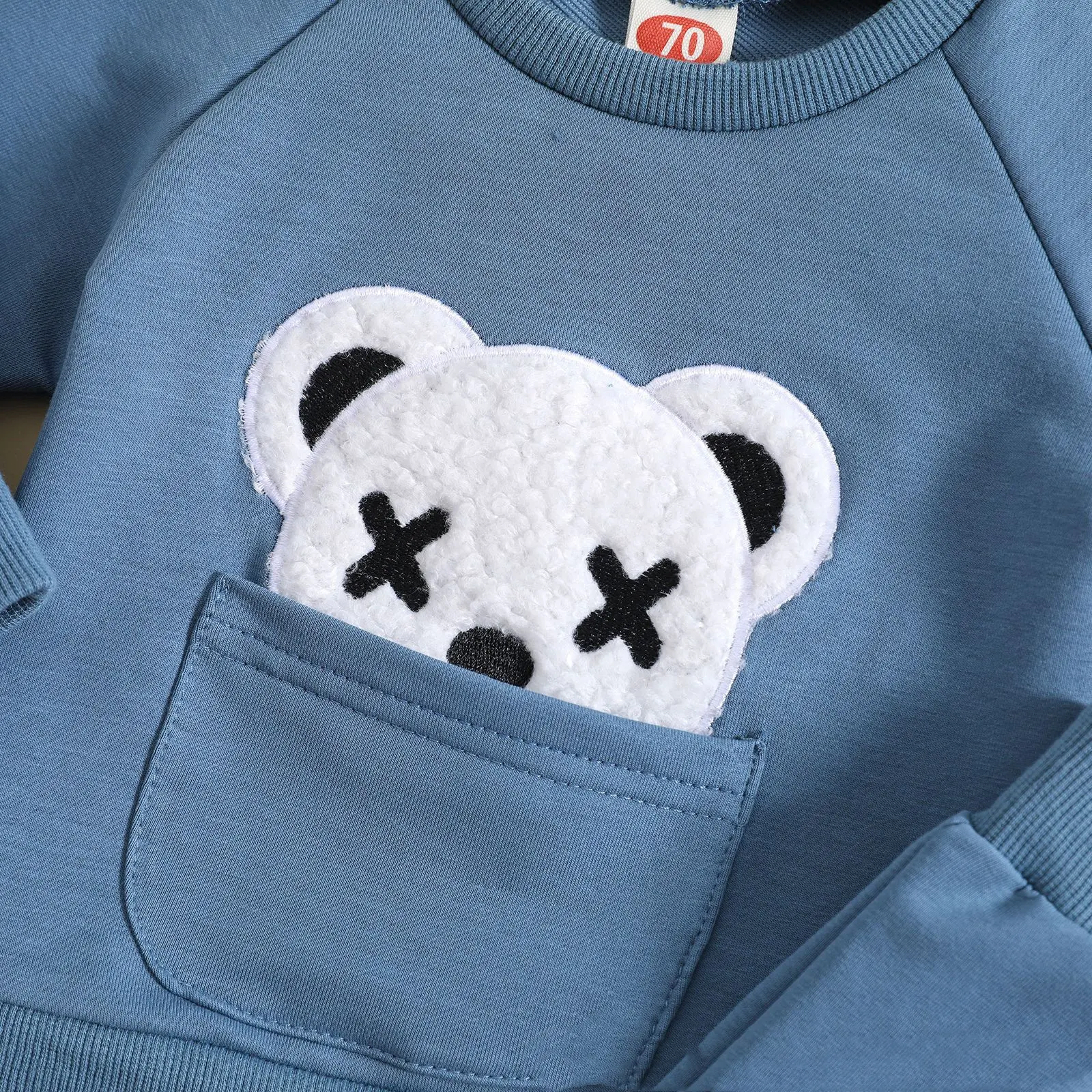 Conjunto infantil de duas peças, suéter branco com gola redonda e bordado de urso, perfeito para ocasiões especiais e conforto. — foto 1