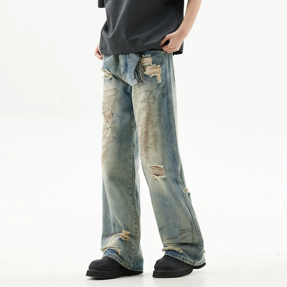 Graffiti distressed dirty ripped denim trousers for a bold urban look. Stylish and comfortable jeans, perfect for a mode — photo 1