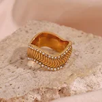 Anel de twill ondulado em aço inoxidável com banho de ouro 18k e pedras nas laterais. Elegância e brilho para o dia a dia. — foto 6