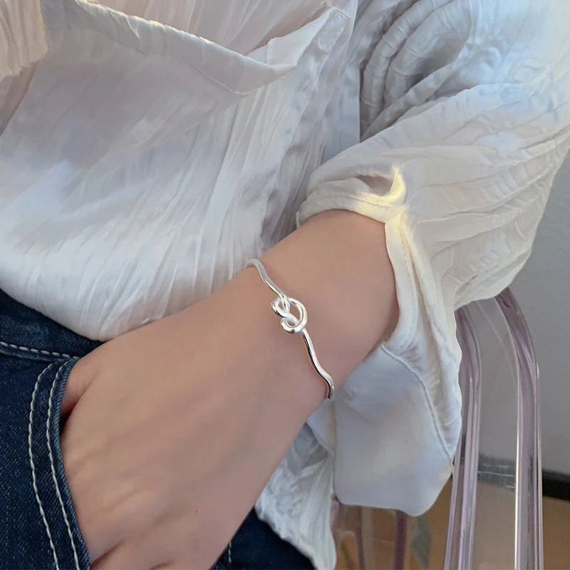 Pulseira de prata aberta com design de coração anudado e ondas para mulheres. Adicione charme e elegância ao seu visual com esta joia. — foto 3
