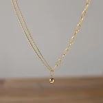 Delicada corrente de clavícula com pequenas bolinhas douradas, proteção de cor ouro 18K. Elegância e durabilidade para você. — foto 1