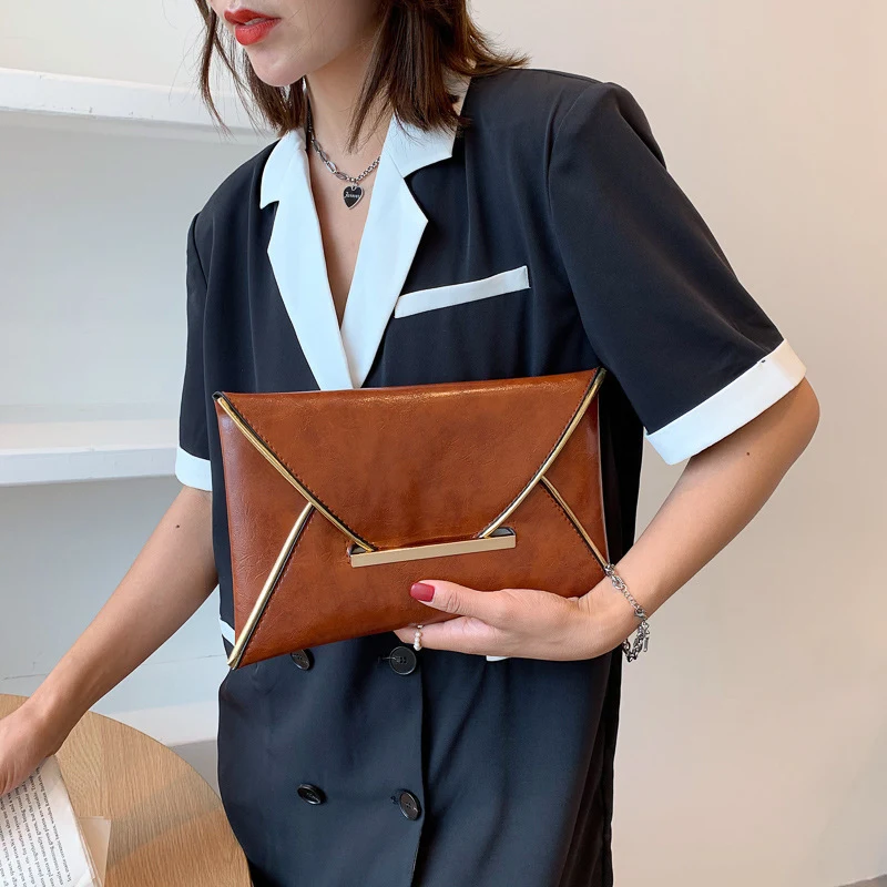 Clutch casual moderna com envelope e cor lisa. Perfeita para um visual despojado e elegante, levando seus itens essenciais com praticidade. — foto 4