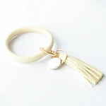 Pulseira com pingente de borla em couro puro, um acessório elegante e versátil que adiciona um toque de charme natural ao seu visual diário. — foto 1