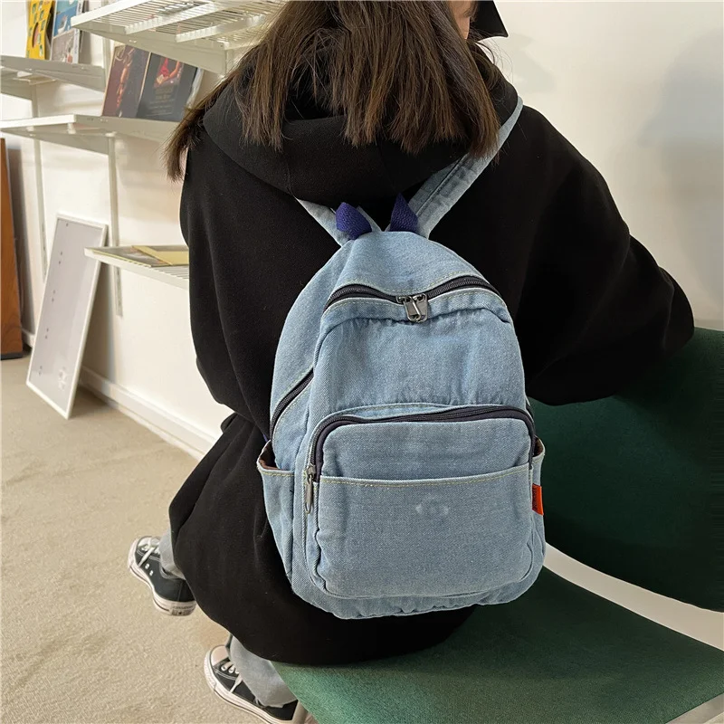 Mochila feminina de lona jeans lavada, perfeita para uso diário e viagens. Confortável, espaçosa e resistente, ideal para transportar seus pertences. — foto 12