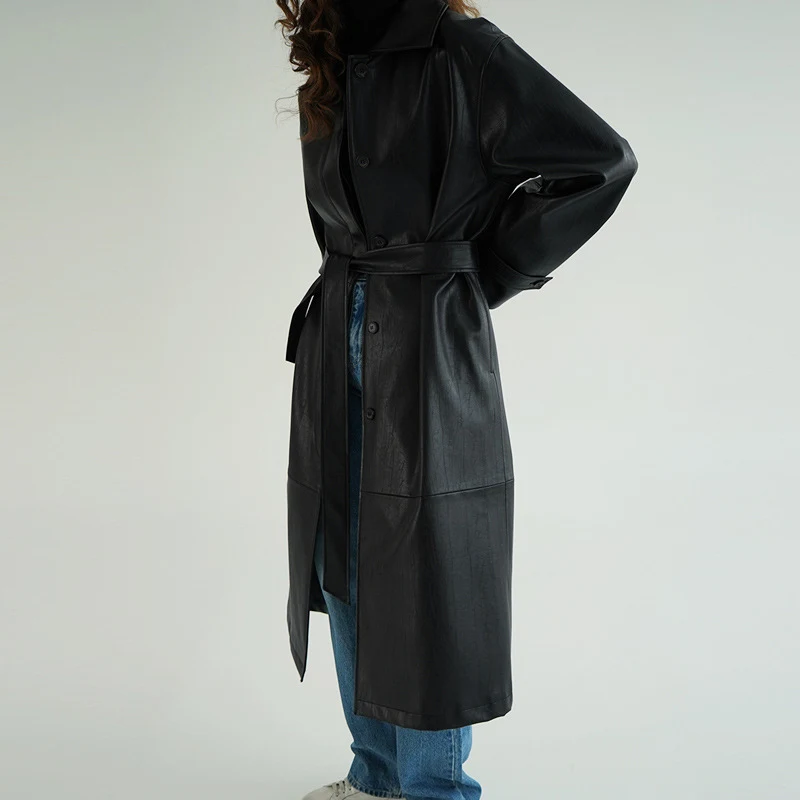 Trench coat longo de couro retrô com lapela, cinto na cintura e abotoamento simples. Elegância e estilo em uma só peça. — foto 4