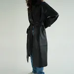 Trench coat longo de couro retrô com lapela, cinto na cintura e abotoamento simples. Elegância e estilo em uma só peça. — foto 4