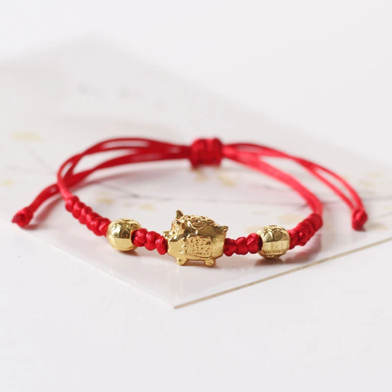 Pulseira de porquinho com corda trançada vermelha e liga ajustável. Um acessório charmoso e moderno para pulsos de todas as idades. — foto 11