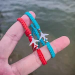 Pulseira com pingente de avião clássico, feita à mão com corda vermelha. Uma joia elegante e cheia de estilo, ideal para uso diário e presentes. — foto 2