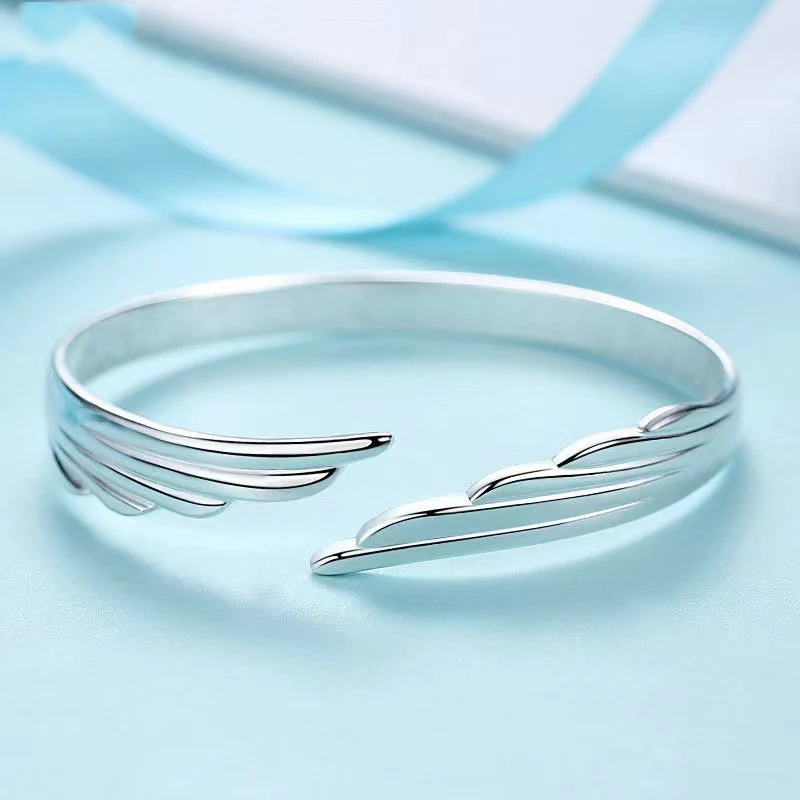Pulseira feminina charmosa com asas de anjo, banhada a prata e cobre branco. Um acessório elegante para complementar seu visual. — foto 2