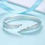 Pulseira feminina charmosa com asas de anjo, banhada a prata e cobre branco. Um acessório elegante para complementar seu visual. — foto 2