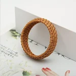 Pulseira redonda vintage de palha trançada, um acessório feminino boho-chic. Adicione um toque rústico e elegante ao seu visual. Perfeita para um look natural. — foto 3