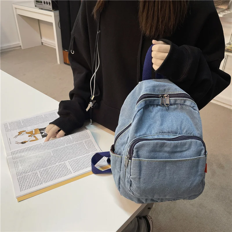 Mochila feminina de lona jeans lavada, perfeita para uso diário e viagens. Confortável, espaçosa e resistente, ideal para transportar seus pertences. — foto 13
