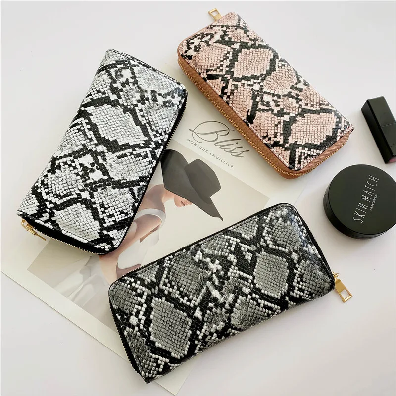 Clutch com zíper e estampa de cobra, um toque de ousadia e sofisticação. Leve seus itens essenciais com estilo e destaque-se em qualquer evento. — foto 1